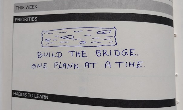 Drawing of a plank and the words "Build the bridge. One plank at a time."